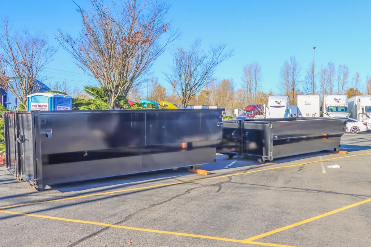 Professional dumpster rental service with roll-off container on residential driveway in Tomball